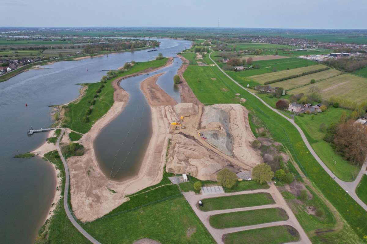  Een overzicht van het projectgebied toont de aanleg van een nieuw waterkanaal en zandbanken langs de rivier.
